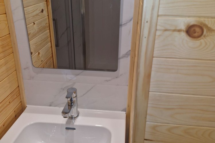 A view of the hand basin, showing the warm wood panelling.